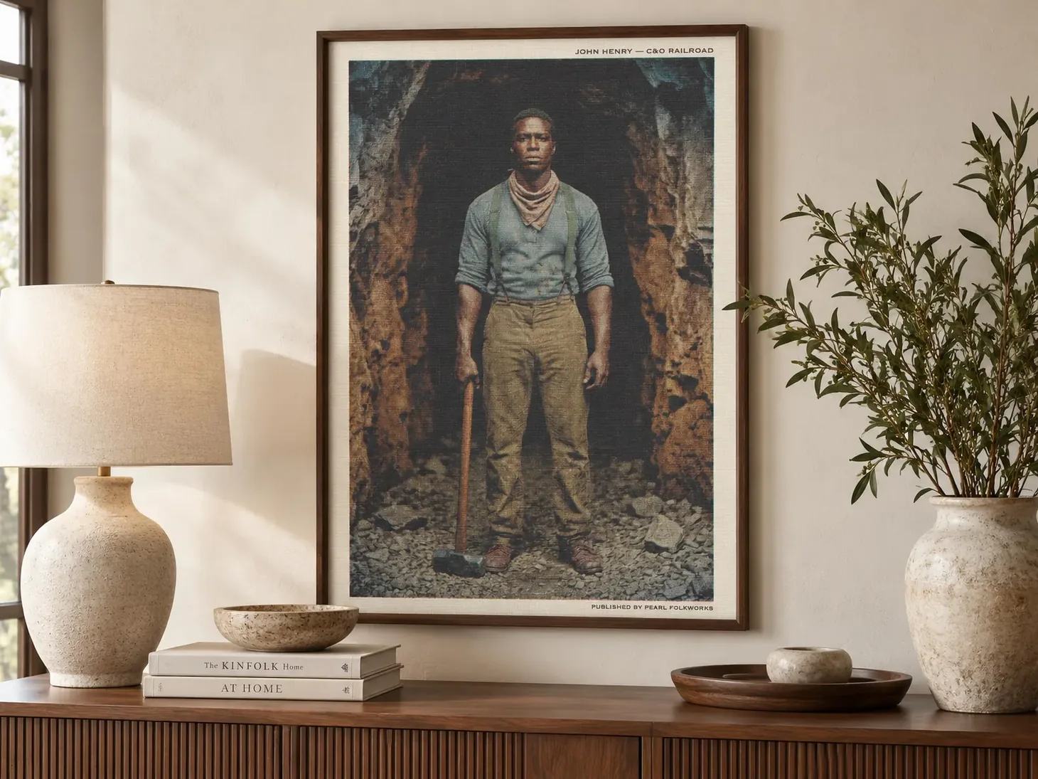 Framed vintage-inspired portrait of John Henry holding a hammer at a railroad tunnel entrance.
